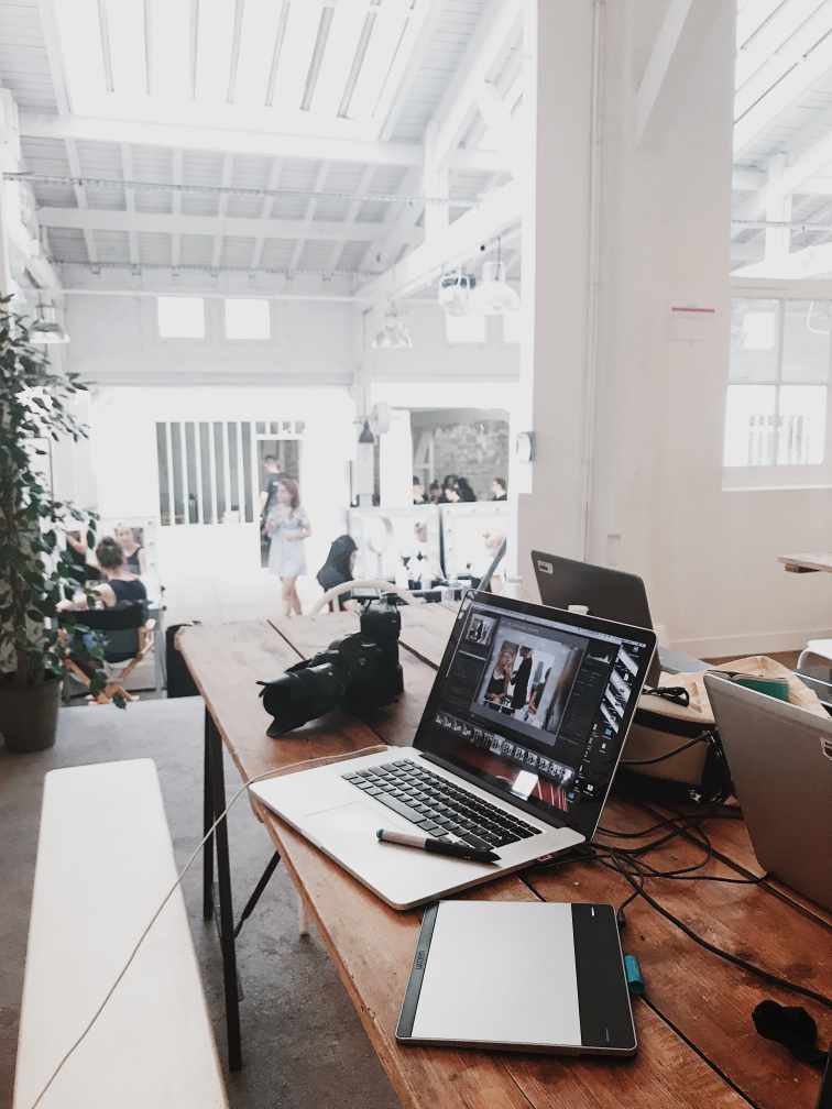 Outsourcing Graphic Design: Your Massive Guide this 2021 9 Laptops, tablet, and camera in the foregrgraphic in a white design studio.