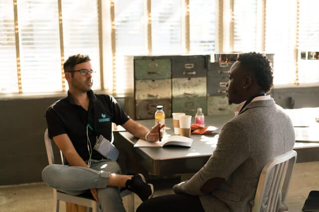 Two men discussing their recruitment in the office, along with strategy for clients, real estate, and web development.